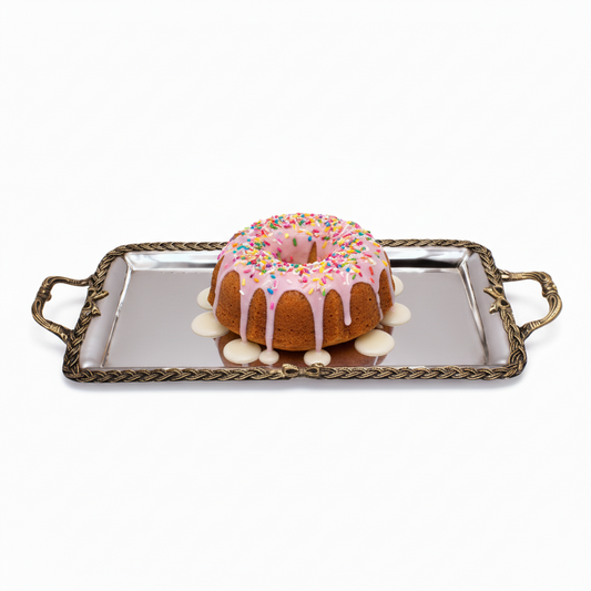 Cinnamon roll on a decorative metal tray with a white background