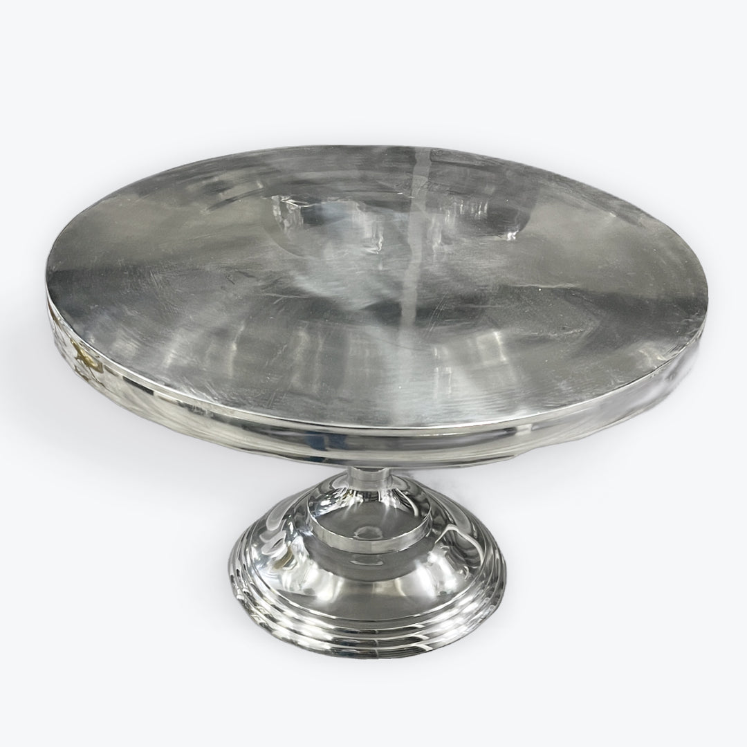 A shiny silver cake stand with a smooth surface and a sturdy base.