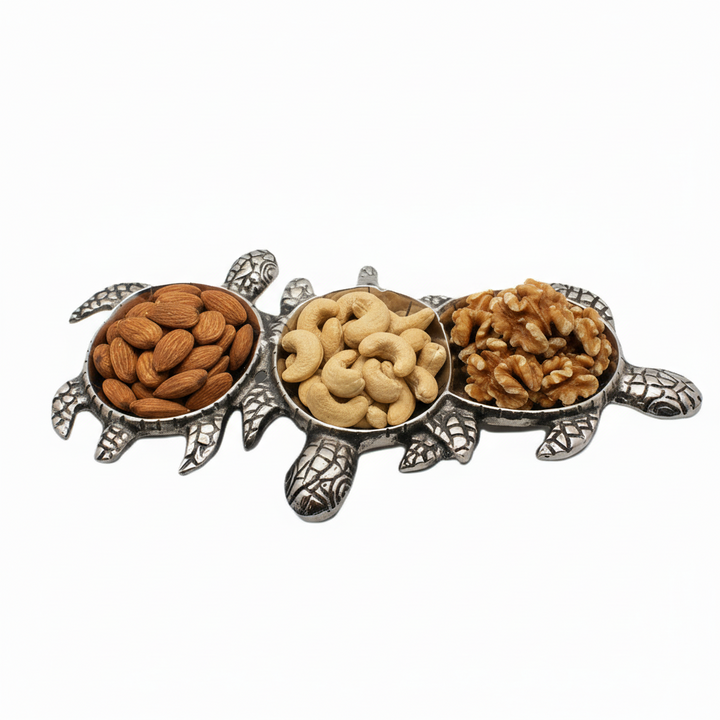 Tortoise-shaped holder with compartments filled with almonds, cashews, and walnuts on a white background
Serving bowl| Aluminum | 310001