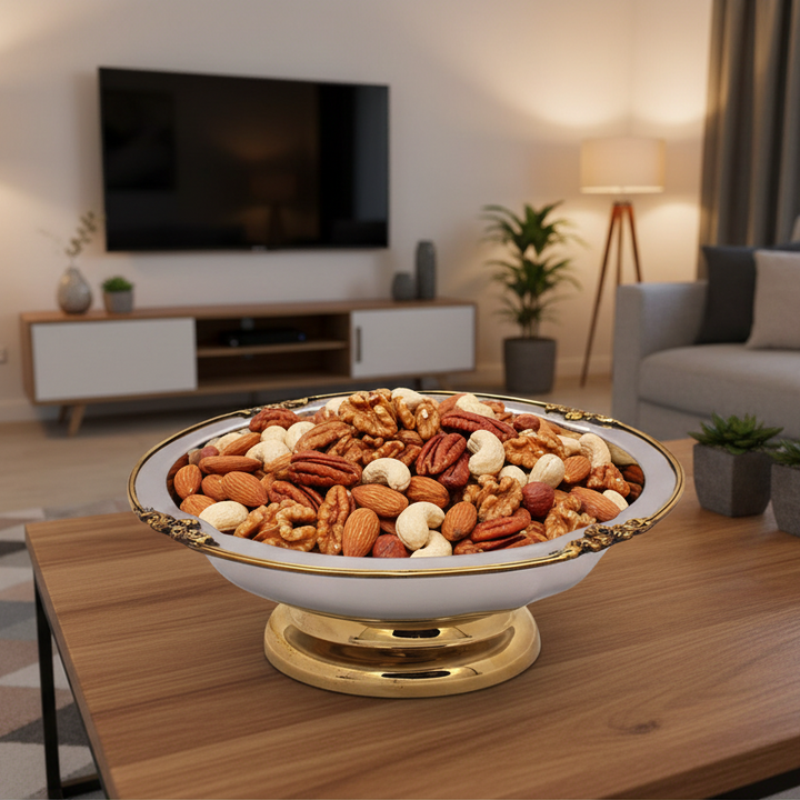 An ornate bowl filled with assorted nuts on a wooden coffee table.